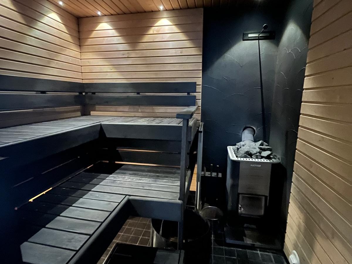 Sauna tummilla pinnoilla ja vaalealla paneelikatolla